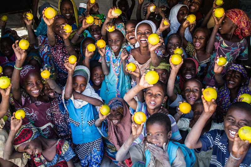 Children holding up oranges - Diffa, Niger