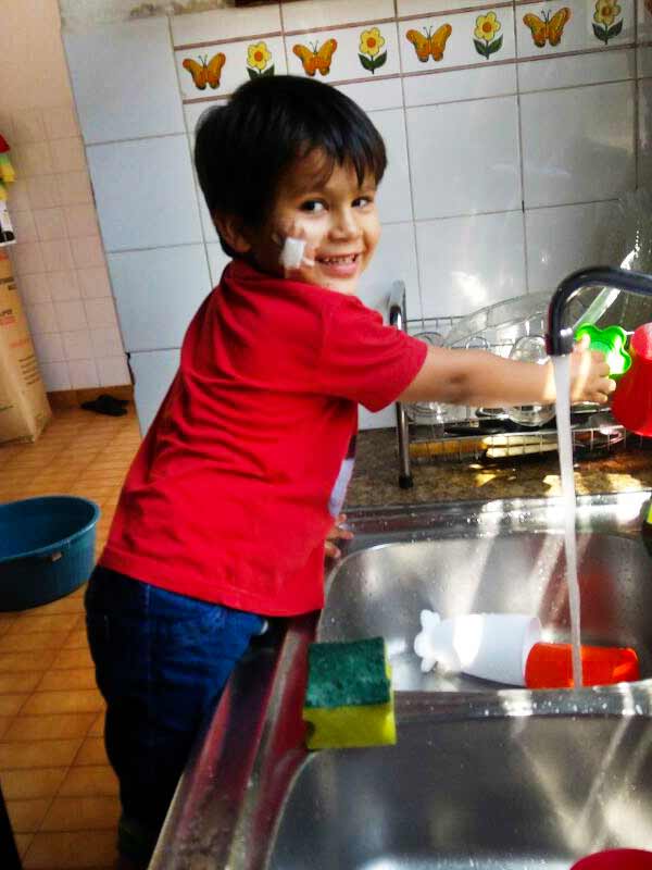 Young boy doing dishes in San Ignacio, Paraguay