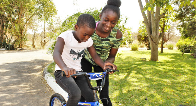 Sister learning to ride a bike