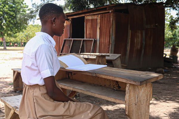 Togo-Atakpame-Adjoua-in-school-uniform-reading_600