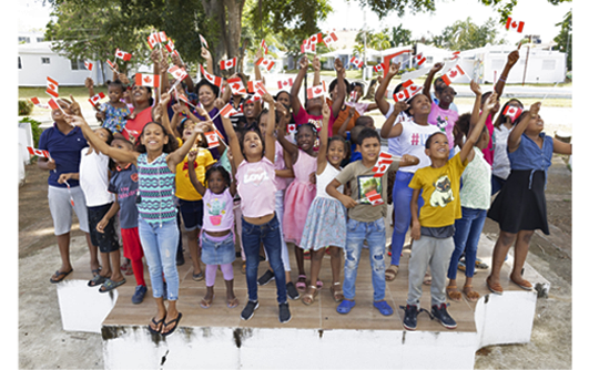 Des enfants en République Dominicaine, chacun tenant un drapeau.