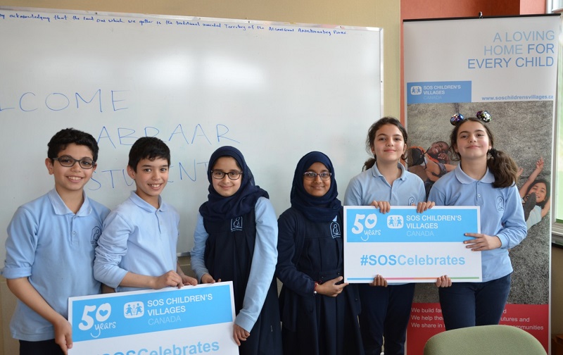Students from Abraar Elementary holding SOS banners