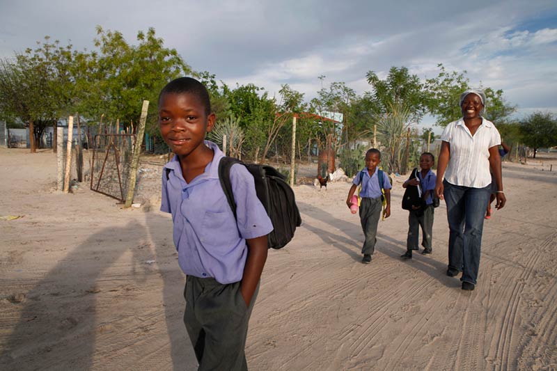 Mère accompagnant ses enfants à l'école en Namibie