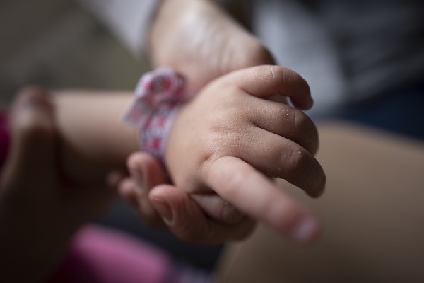 Close up of Dasha holding her infant daughters hand.