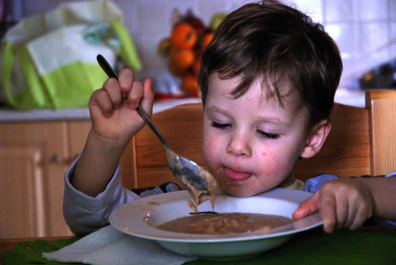 Boy eating stew in Plagiari, Greece