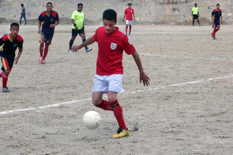 Garçon jouant au football au Népal
