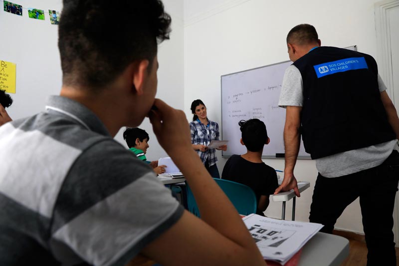 Garçons assis dans une salle de classe dans le centre de réfugiés pour garçons à Athènes, Grèce