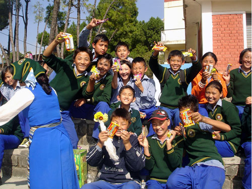 Tibetan children having sweets in Gopalpur, India