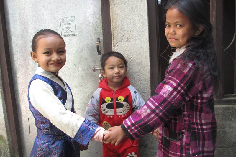 Child playing and holding hands, Nepal