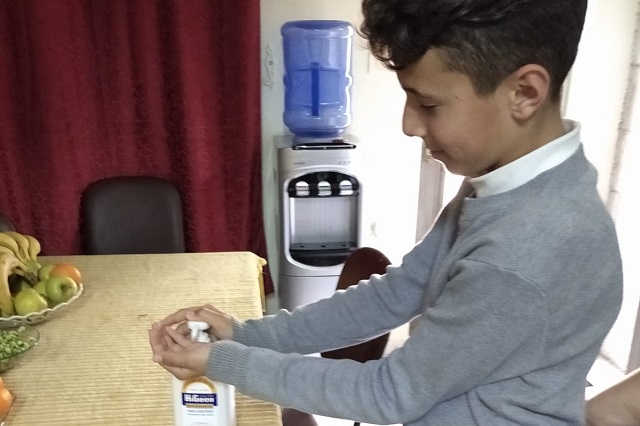 An SOS child washes his hands.