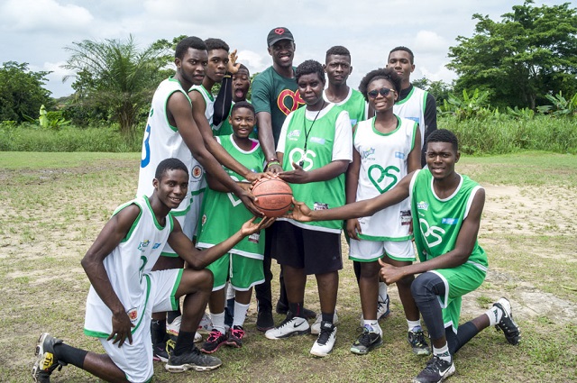 Pascal Siakam et les jeunes de Camaroon posent avec un ballon de basket.