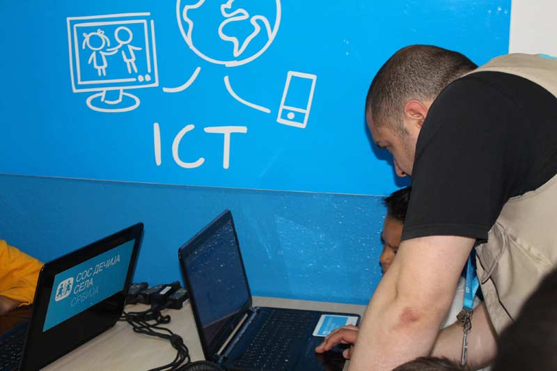 Aleksandar Guševski montre à un visiteur du coin ICT comment jouer à un jeu.