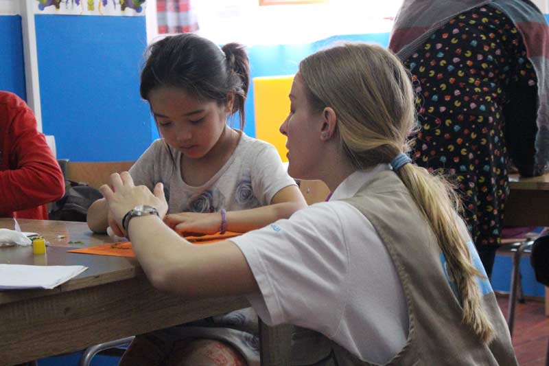L'éducatrice Jelena Vićentijević aide une petite fille en classe à terminer son projet.
