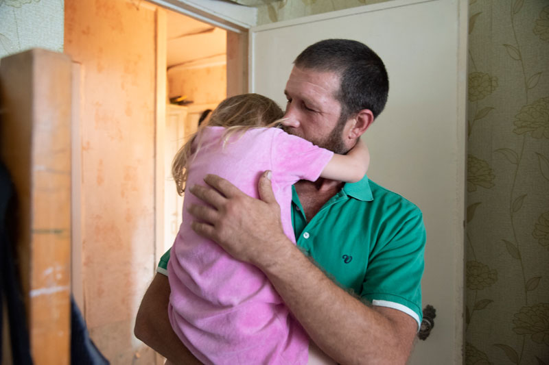Father hugging young daughter in Eastern Ukraine