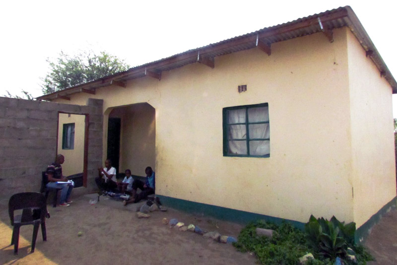 Family sitting in front of their new home built by SOS in Francistown, Botswana