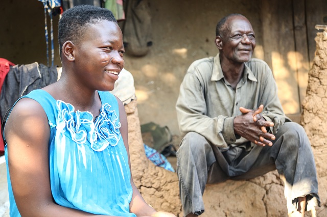 Marikah smiles while her father is being interviewed.