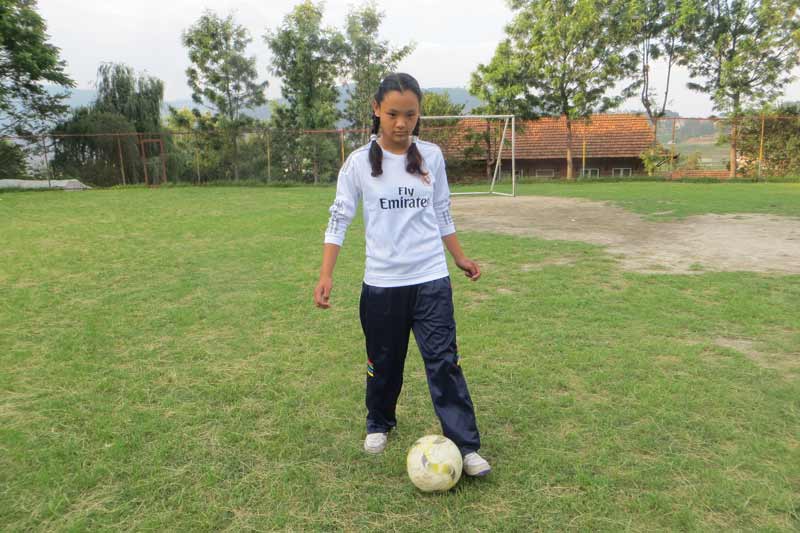 Fille jouant au football au Népal