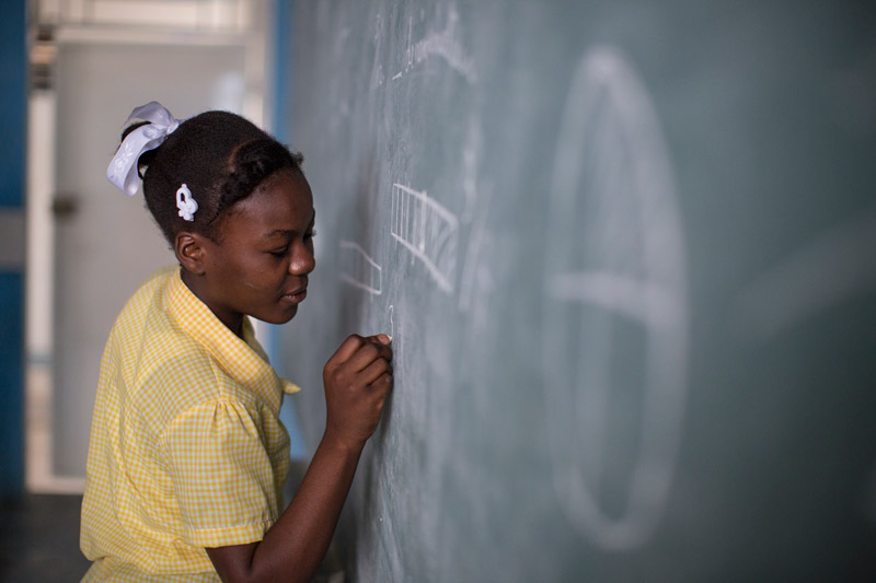 Girl writing on blackboard