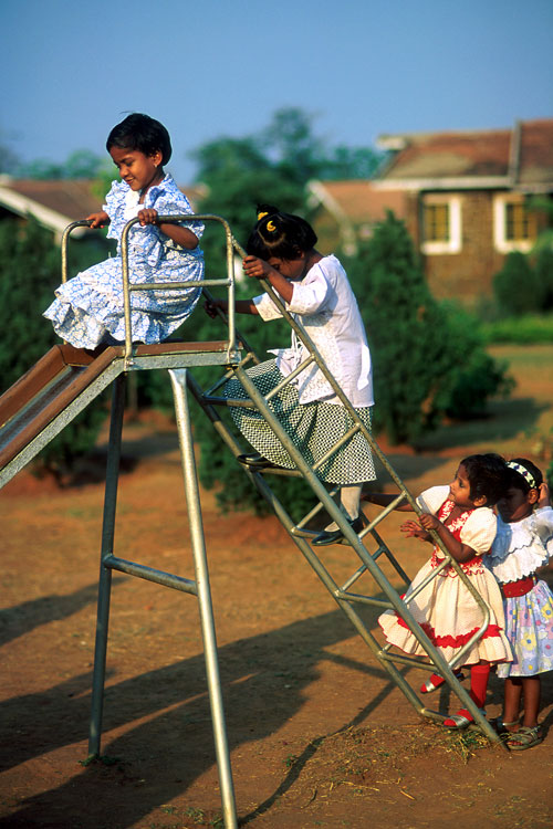Girls in dresses using a slide in Rourkela, India