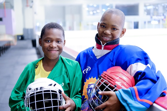 Khaya* and Pieter* smiling in their hockey gear