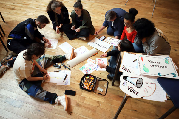 Youth making posters at an Applying Safe Behaviours event.