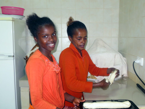Mimi baking with her SOS Mother in Harrar, Ethiopia.  Child sponsorship in Ethiopia gives orphans a mother and a home.