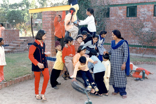 Mother and children playing in playground in Rajpura, India