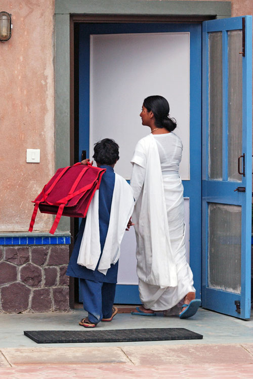 Mother welcoming child back from school in Khajuri Kalan, India
