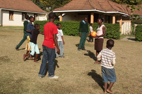 Neema playing soccer with children in Tanzania