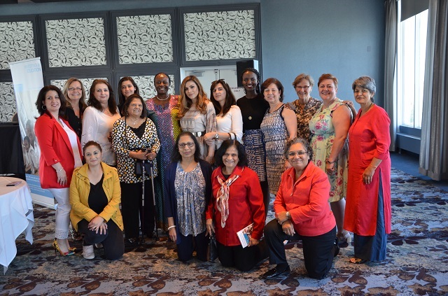 Olive Lumonya et les femmes de l'événement High Tea posant ensemble.