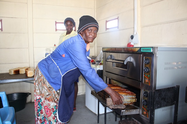 Wambi pulling fresh baked bread from the oven