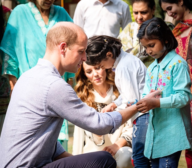 The Duke of Cambridge receiving a friendship bracelet from Khadija.