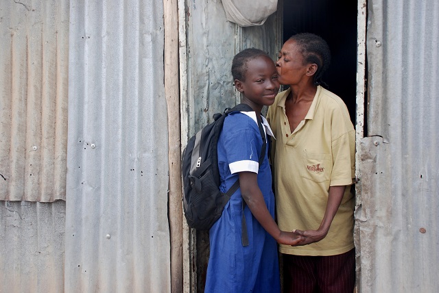 SOS mother kissing her daughter goodbye.