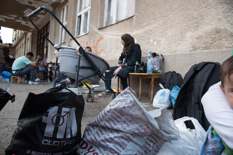 Refugees waiting at a train station with their belongings in Macedonia