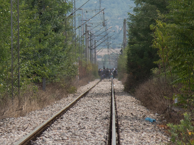 Refugees walking down railroad track in Gevgelija, Macedonia