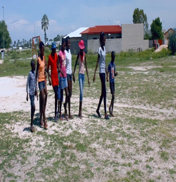 Des enfants namibiens marchant devant des foyers SOS