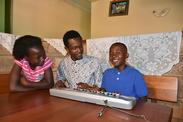 SOS Children de Rodah pratiquant sur un clavier de piano.