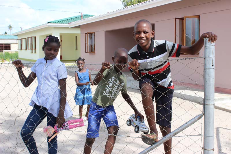 Edricio climbing a fence with his siblings