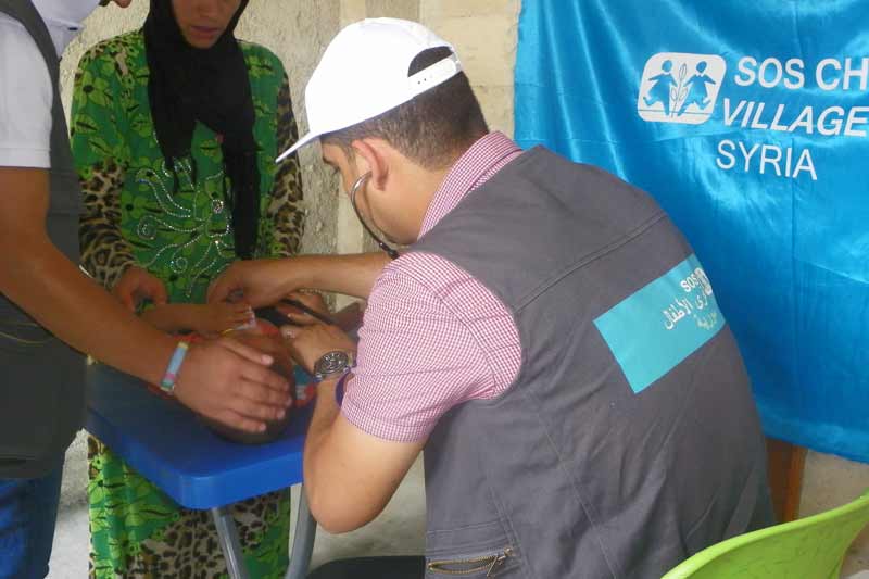 SOS doctor providing care to Syrian infant