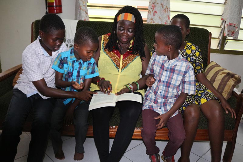 SOS family reading together in Ghana