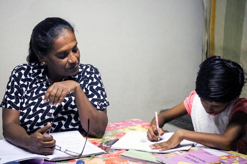 La mère SOS Malani aide sa fille à faire ses devoirs