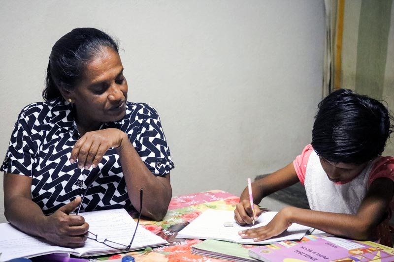 SOS mother Malani helping her daughter with homework