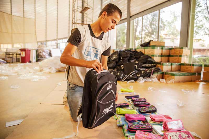 SOS worker preparing school bags for children