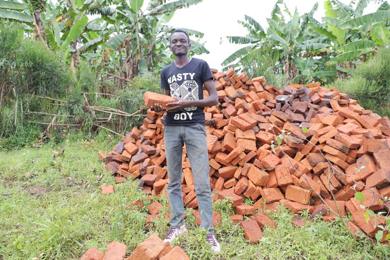 Stephen with pile of bricks behind him