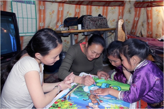 Arban* and her sister working on their studies, with help from mom.