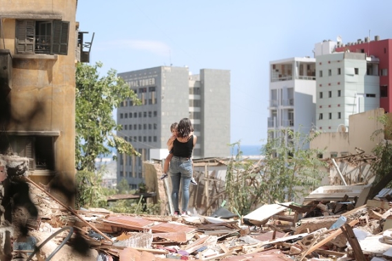 A mother and daughter walk through the debris of their apartment complex
