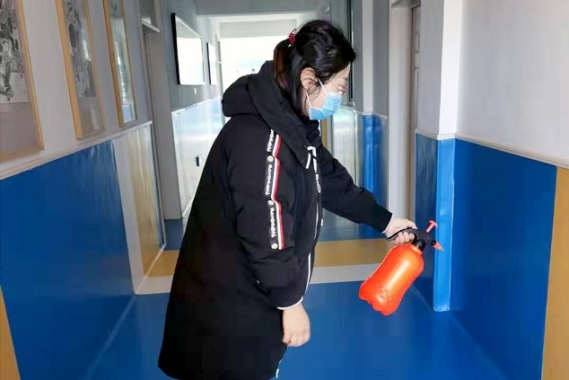 A woman disinfects an SOS school.