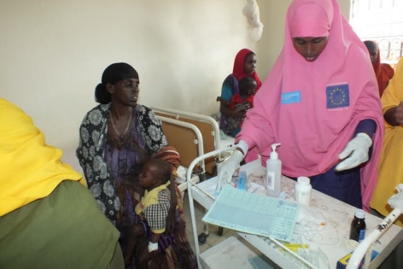 A nurse treating a mother at an SOS medical centre.