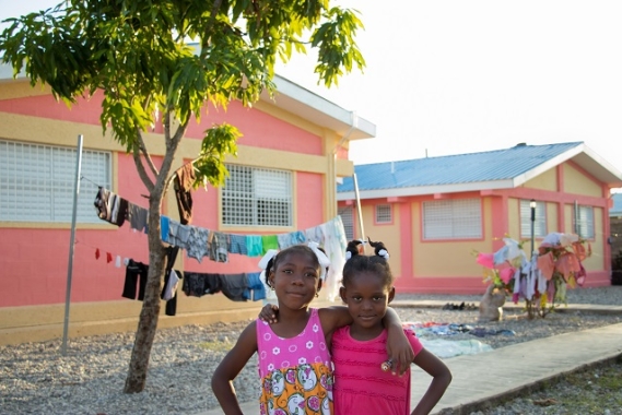 Deux enfants SOS souriants devant leur nouveau foyer SOS.