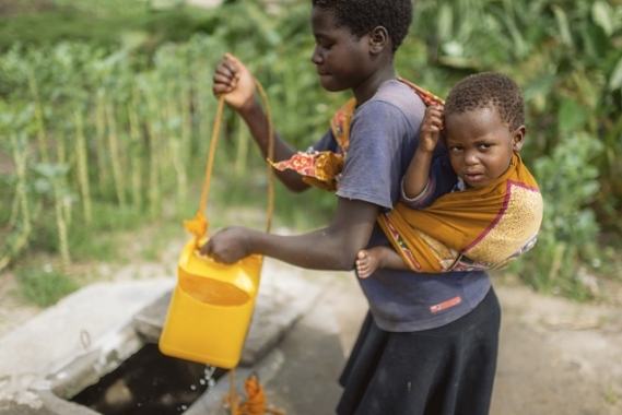 Tia getting water with her younger brother.